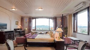 Une chambre d’hôtel avec un grand lit, un bureau, une télévision et une vue sur la ville.