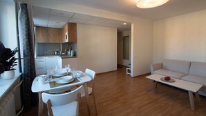 Un salon moderne avec un coin repas, un canapé et une cuisine en arrière-plan.