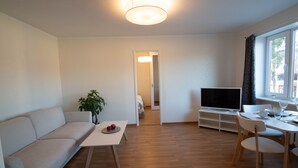 Un salon moderne avec un canapé, une table à manger et un téléviseur.