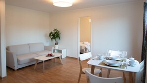 Un salon moderne avec un canapé, une table basse et une table à manger dressée pour le repas.