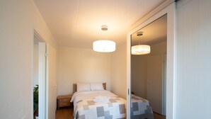 Une chambre à coucher avec un lit, une table de chevet et un miroir.