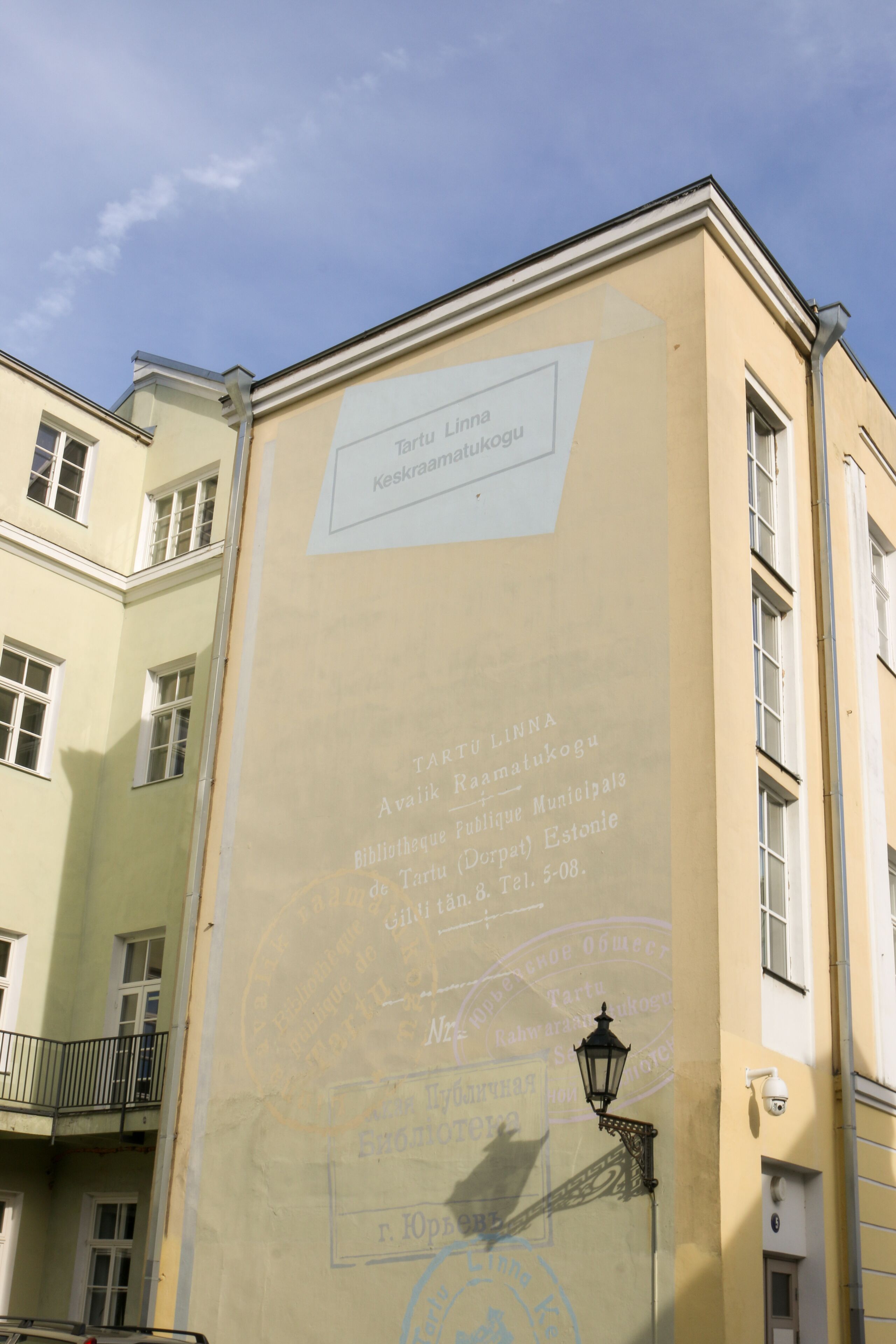 A building facade with a sign indicating it is the Tartu Linnu library.