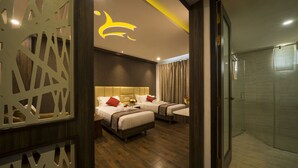 A hotel room with two beds, a shower, and a decorative ceiling light.