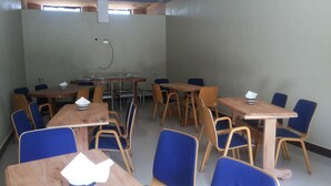 A room with multiple tables and chairs, arranged in a classroom or meeting room layout. - Skypa Hotel (Yumbe)