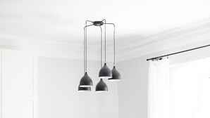 Una cocina moderna con armarios blancos, microondas y comedor con mesa y sillas.