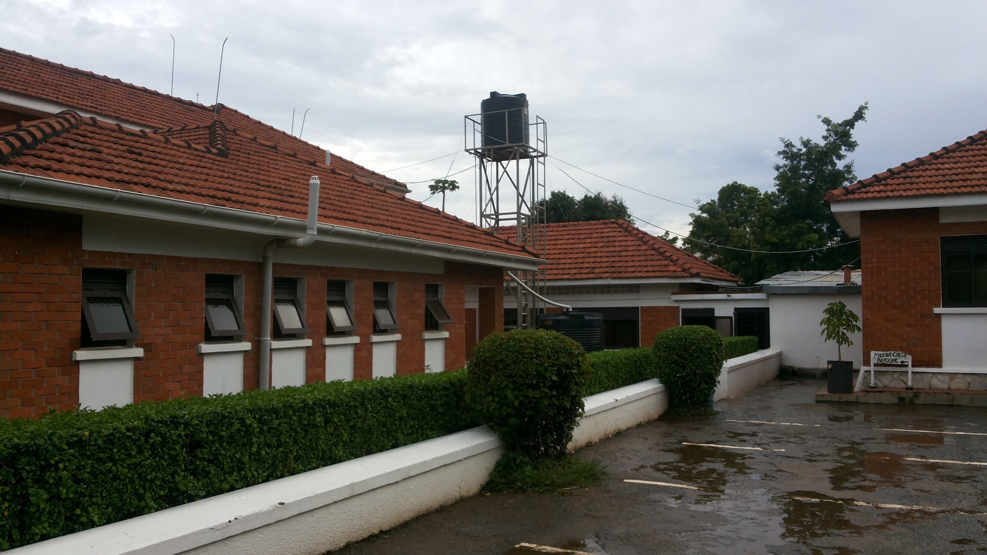A building with a tiled roof, brick walls, and a water tower.