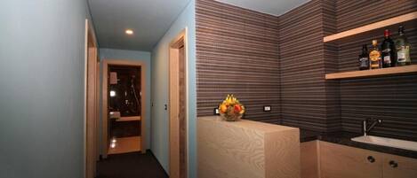Une salle de bain moderne avec un meuble-lavabo en bois, un évier et une étagère contenant des articles de toilette.