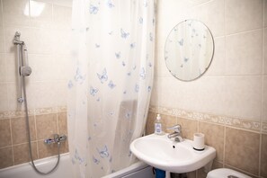 A bathroom with a shower, a sink, a toilet, and a mirror. - Aura City Center Tartu Holidays (Tartu)