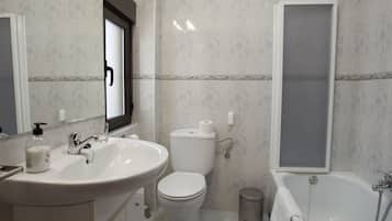 Uma casa de banho com lavatório, sanita e banheira.
