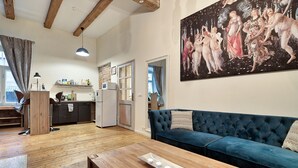 A living room with a blue sofa, wooden coffee table, and a painting on the wall.