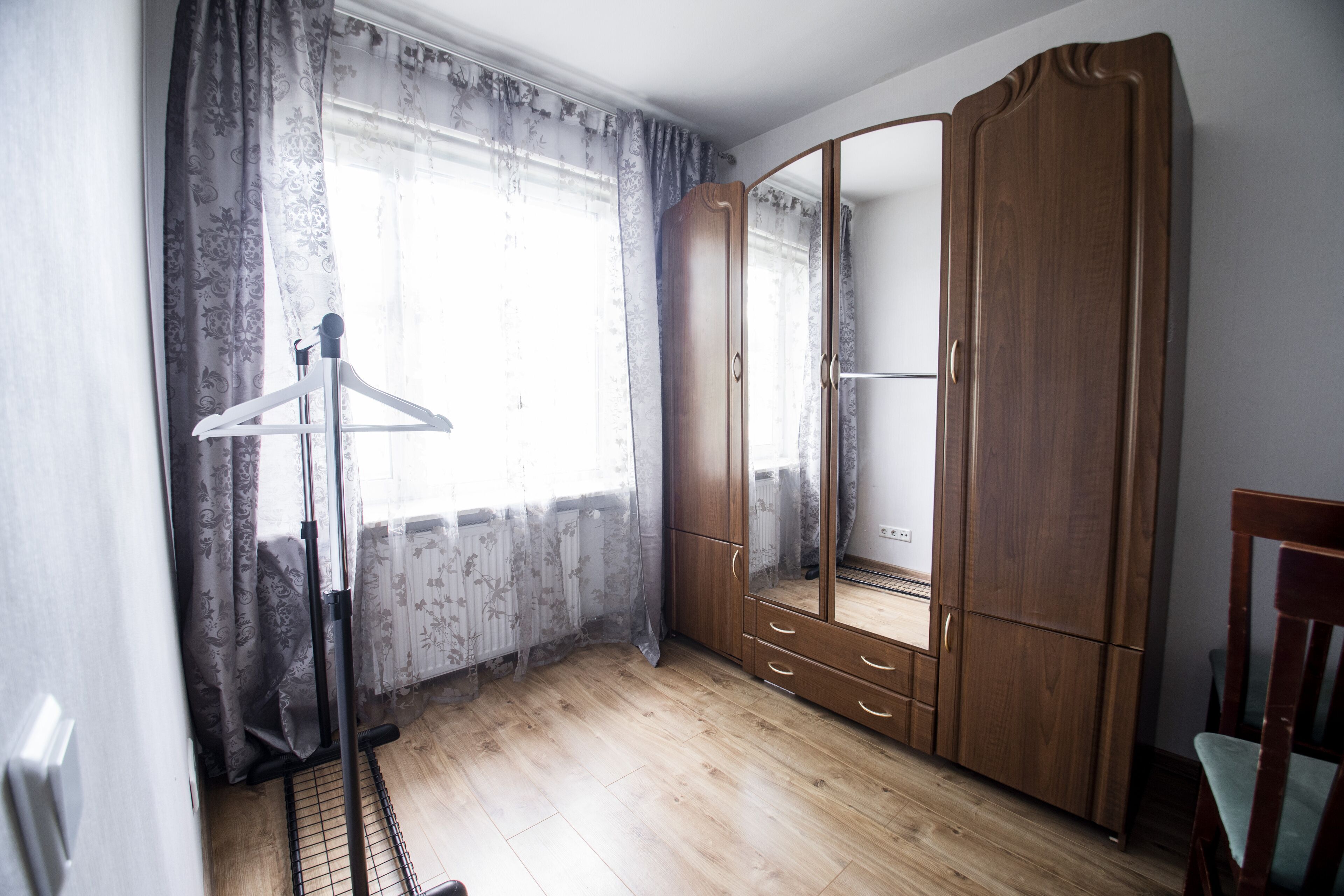 Une pièce avec une armoire en bois, un miroir et un radiateur.