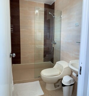 A bathroom with a glass-enclosed shower, a toilet, and a sink. - Hotel Libano (San Francisco de Macorís)