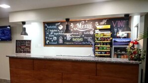 A reception area with a wooden counter, a chalkboard menu, and a vending machine. - Hotel Libano (San Francisco de Macorís)