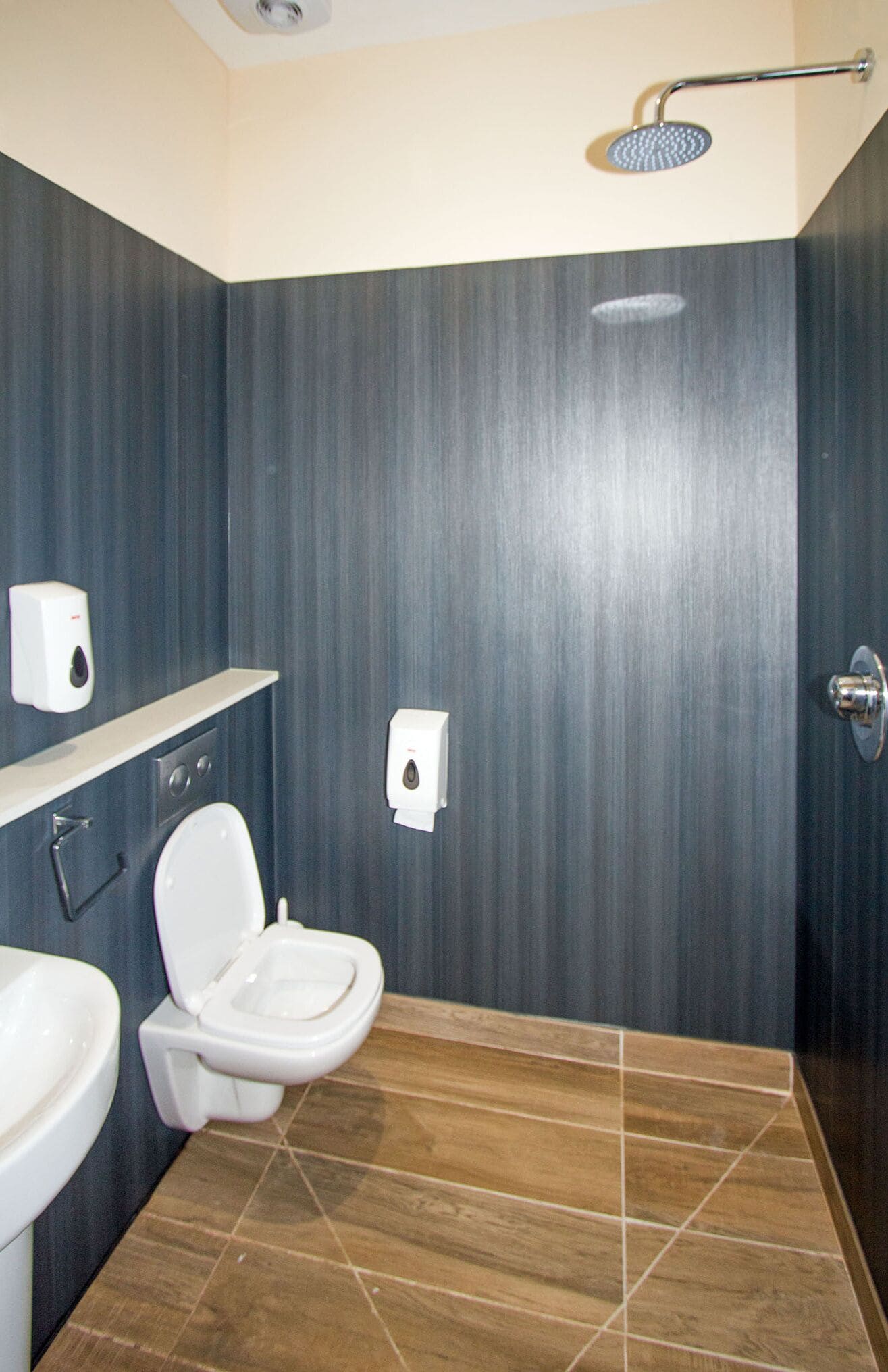 A bathroom with a toilet, sink, and shower.