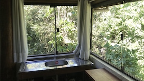 A kitchen with a window, a sink, and a wooden counter. - Pousada Paraíso do Luz (Imbituba)