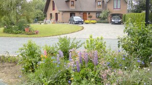 Ein zweistöckiges Haus mit Ziegelaußenwand, einem Ziegeldach und einer Auffahrt, die zu einer Garage führt.