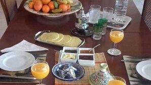 Taula de dinar posta amb plats, gots i un bol de fruita.