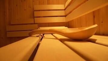 A wooden sauna with benches and a large bowl.