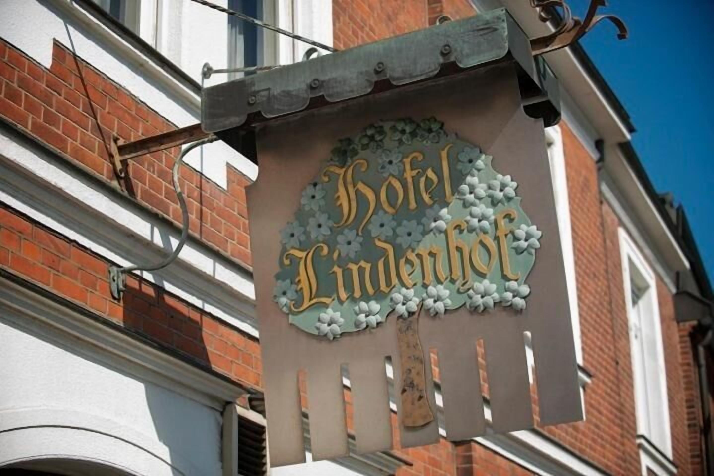 Letrero del 'Hotel Lindenhof' con un borde decorativo y elementos colgantes.