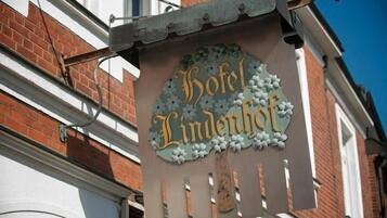 Letrero del 'Hotel Lindenhof' con un borde decorativo y elementos colgantes.