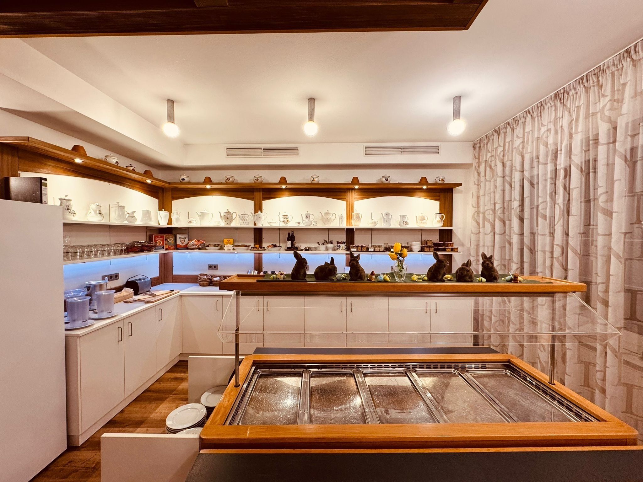 Una cocina moderna con armarios blancos, una isla central y una pared decorativa con un diseño.
