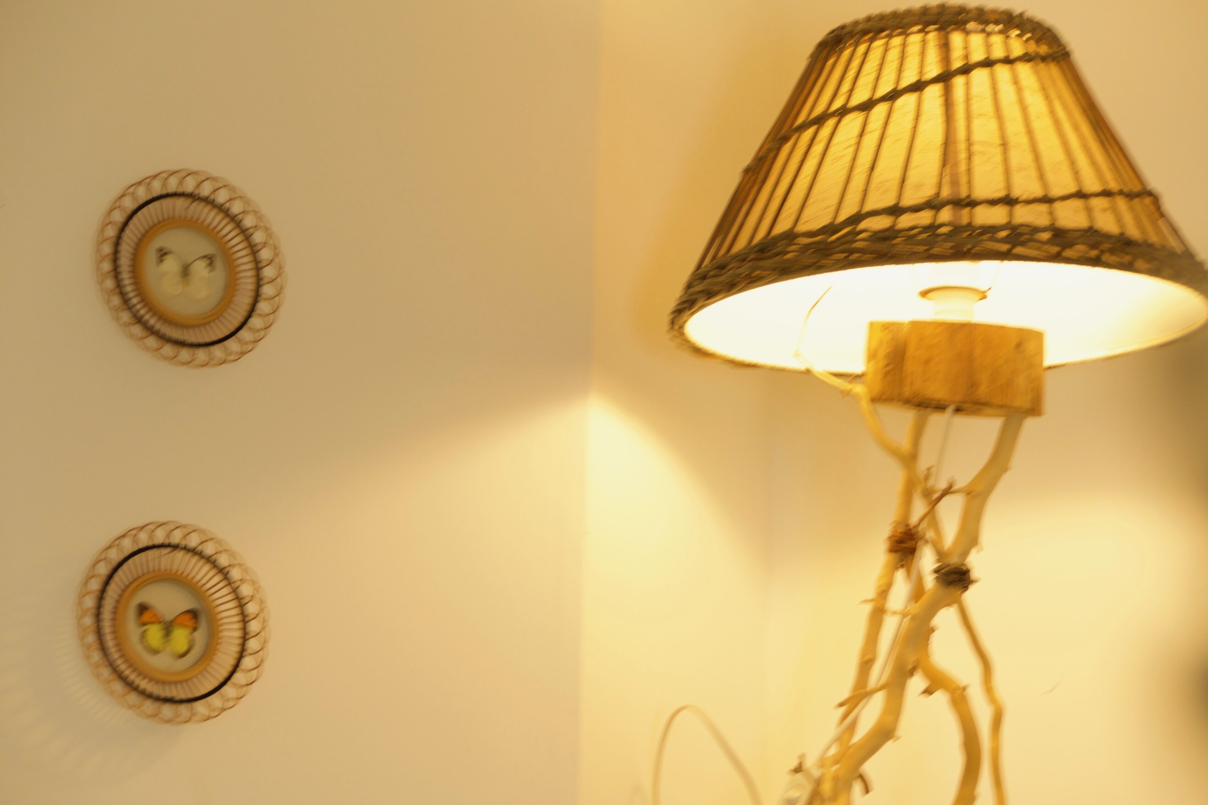 A wall with two circular wall art pieces and a floor lamp.