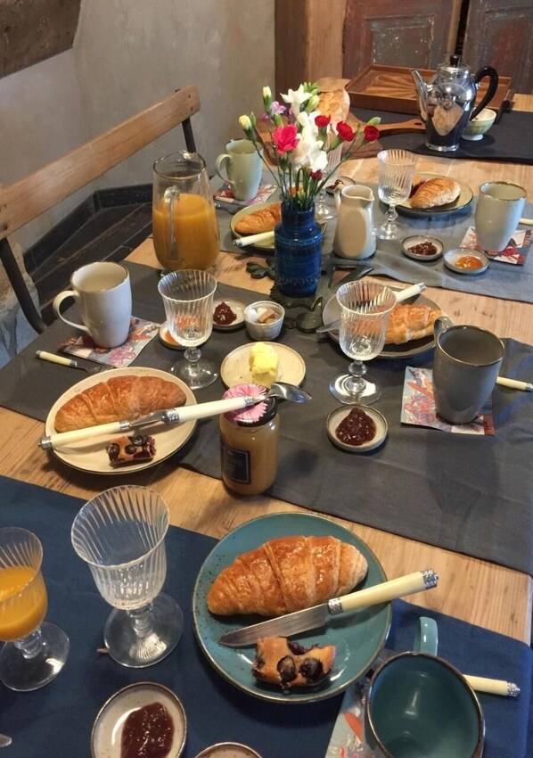 A breakfast table with various food items, drinks, and a teapot. - Maison du Figuier (Lancie)