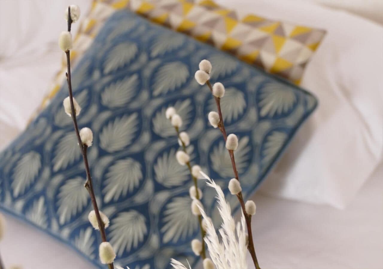 A patterned fabric with a blue and white design, possibly a bedspread or blanket.