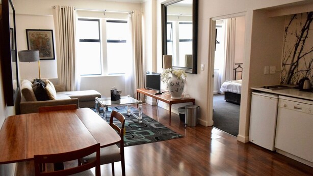 Un espace de vie compact comprenant un coin repas, une kitchenette et une chambre.