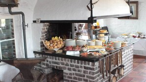 Un buffet de petit-déjeuner proposant une variété de plats et un four à pizza traditionnel.