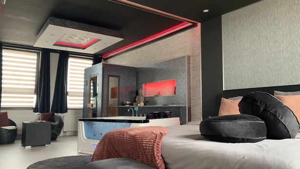 Une chambre à coucher moderne avec un grand lit, une coiffeuse et une baignoire.