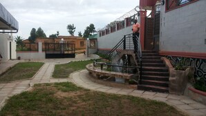 Un patio con una fuente, una escalera y una entrada con reja.