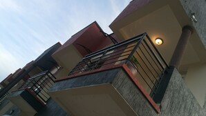 Un edificio residencial de varios pisos con balcones, fachada de concreto y una lámpara visible.