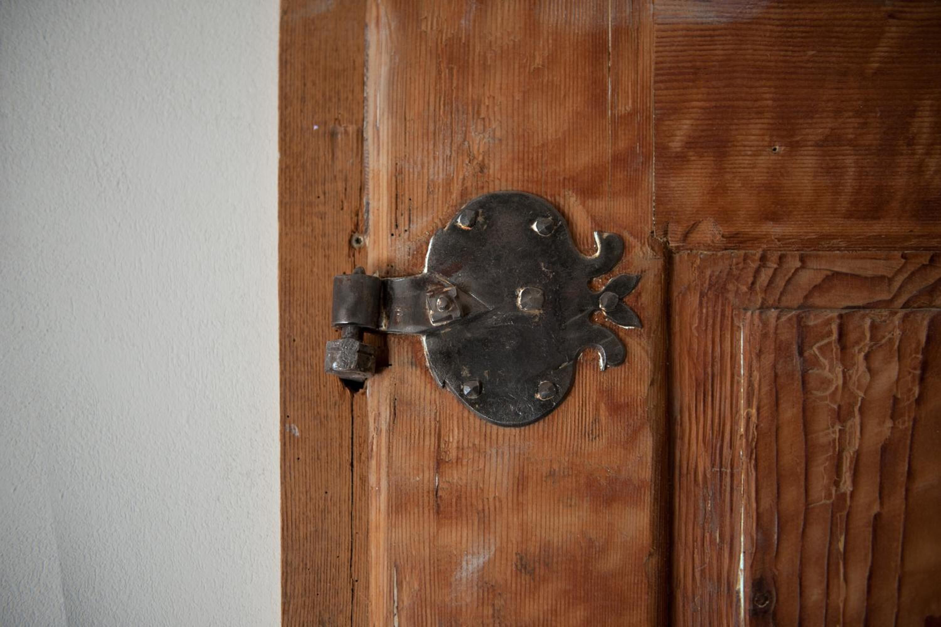 Una puerta de madera con un pestillo metálico.