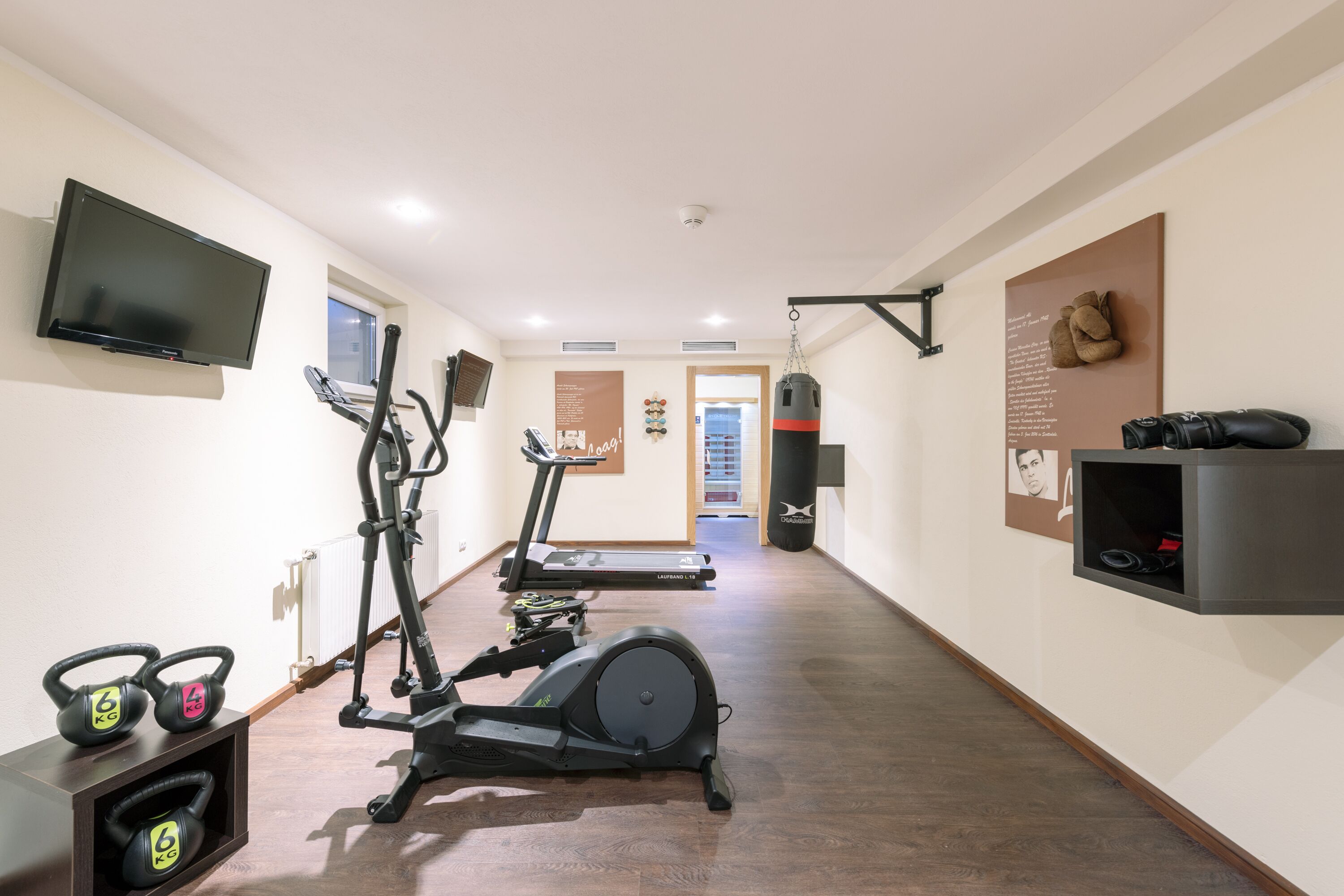 Un gimnasio con cintas de correr, una bicicleta estática y mancuernas.
