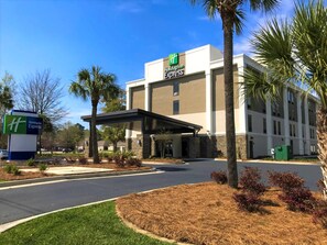 A Holiday Inn Express building with a covered entrance, palm trees, and a clear blue sky. - Holiday Inn Express Statesboro by IHG (Statesboro)