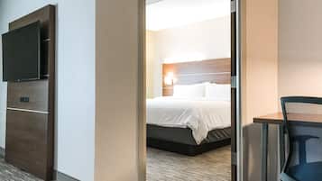 A hotel room with a bed, a television, and a desk.