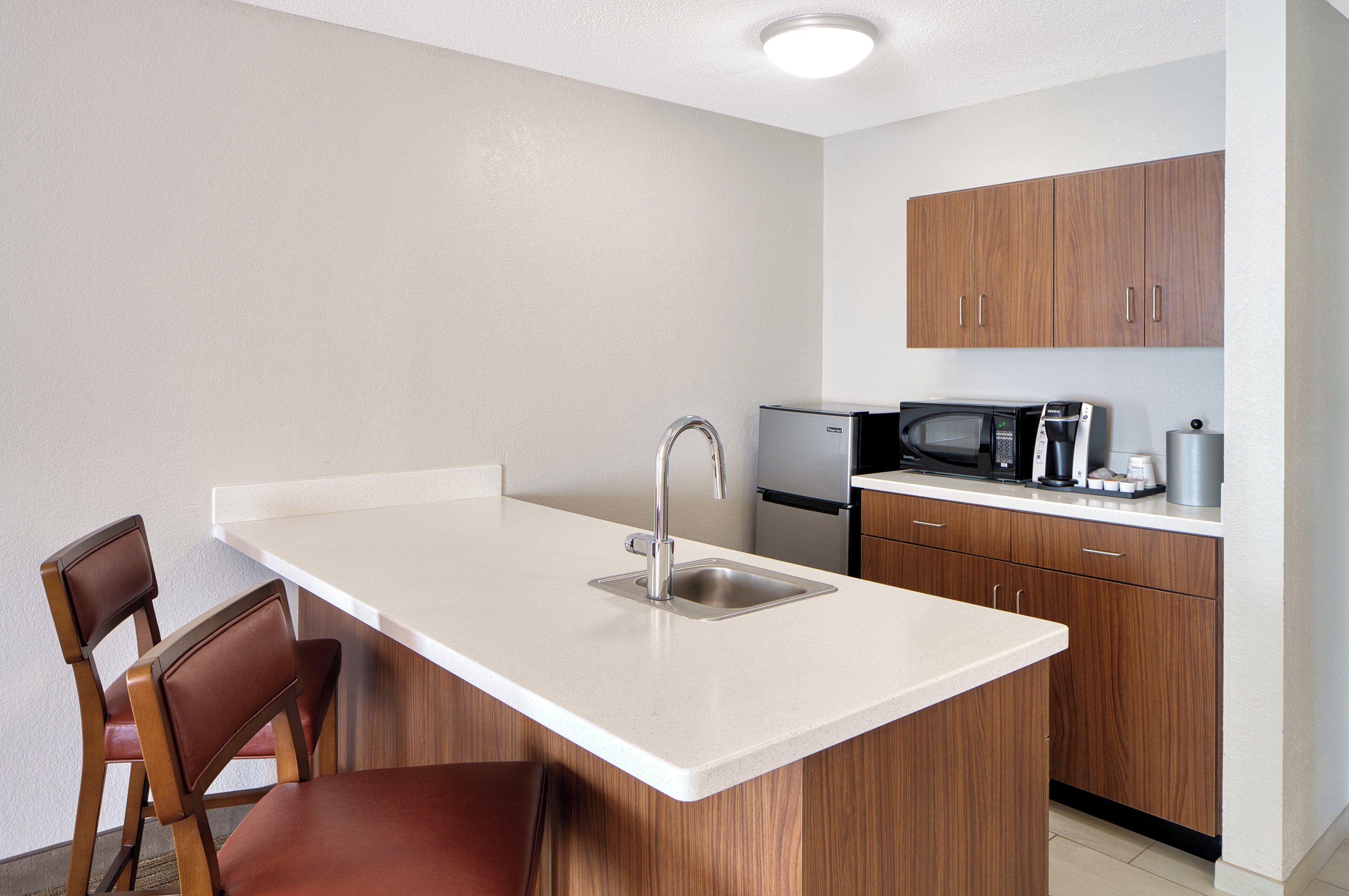 A compact kitchen with a sink, a microwave, and a coffee maker.