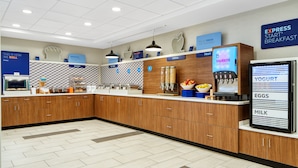 A modern breakfast area with a self-serve station, including options for cereal, fruit, yogurt, eggs, and milk. - Holiday Inn Express Statesboro by IHG (Statesboro)