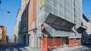 A building under construction with scaffolding and orange safety barriers. - Elegant Pol's Loft  (Trieste)