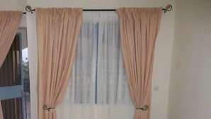 Une chambre à coucher avec un lit, des rideaux et une fenêtre.