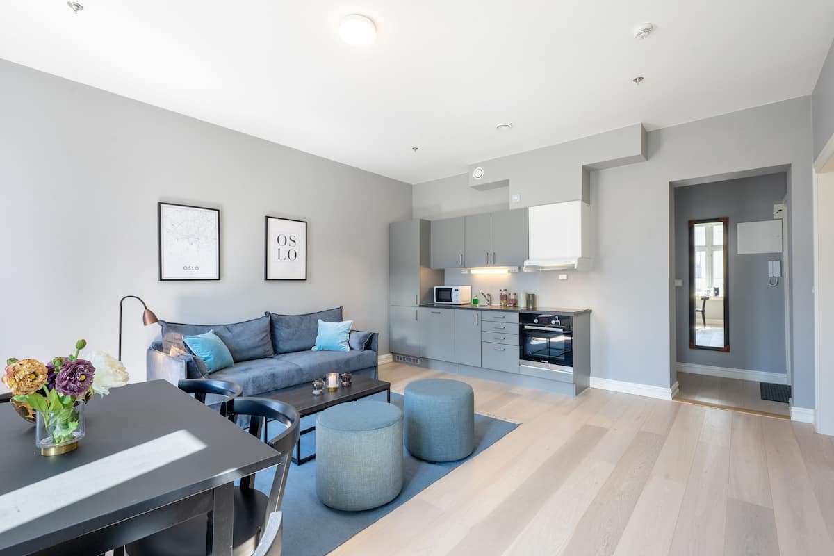 A modern apartment with a living room, dining area, and kitchen.
