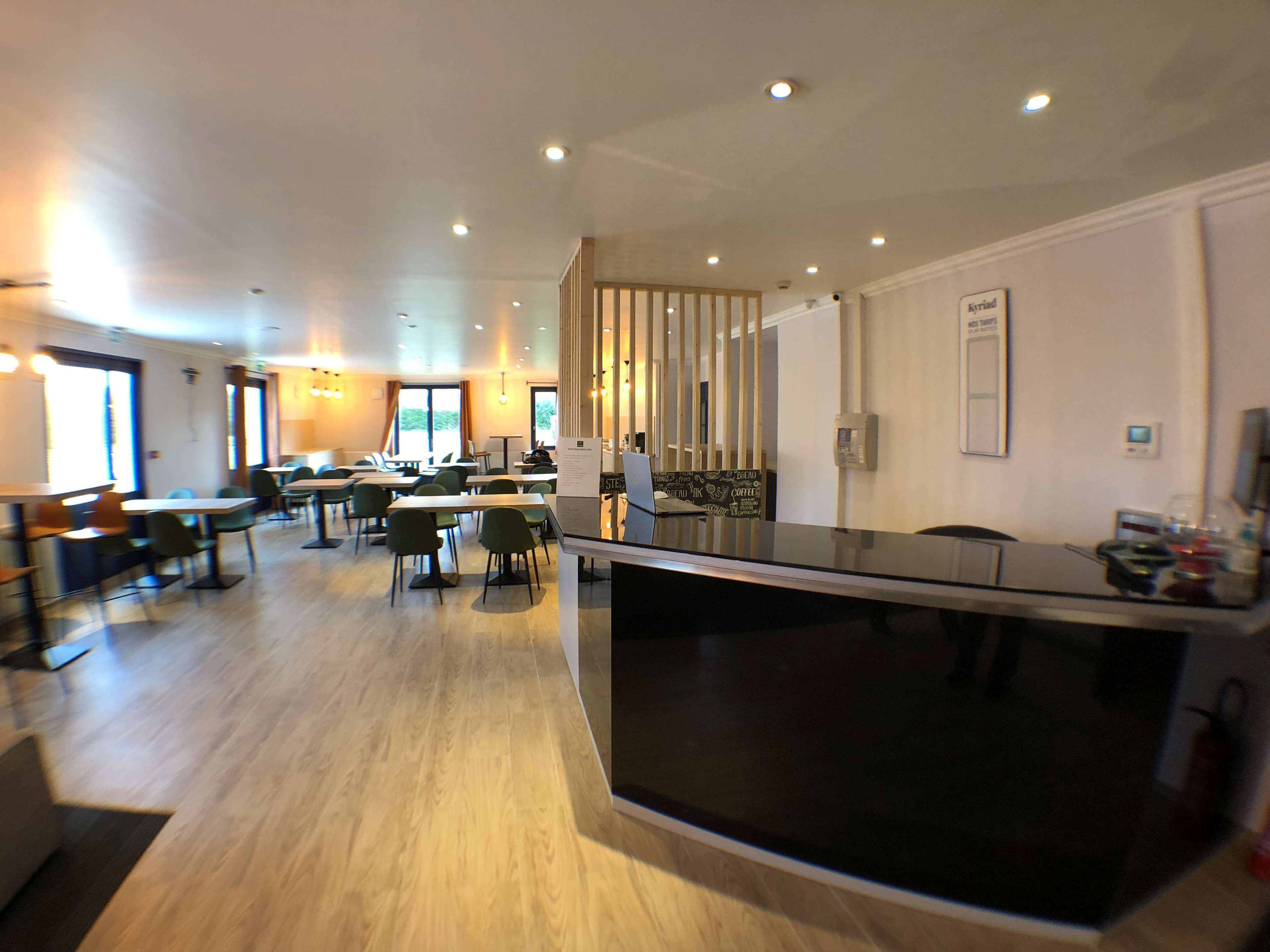 Un moderno vestíbulo de hotel con un mostrador de recepción central, varias zonas de estar y vistas al exterior a través de amplios ventanales.