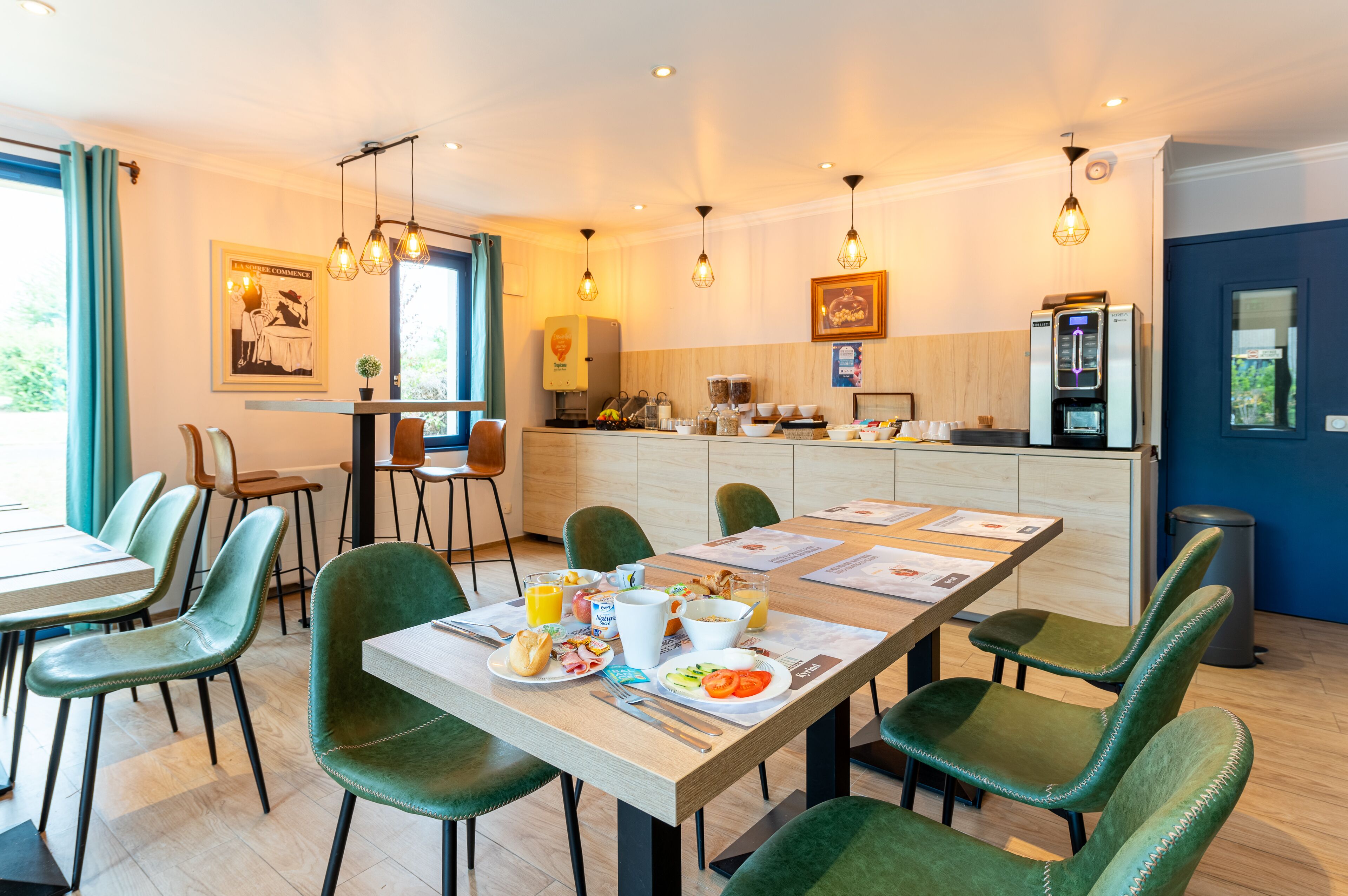Un comedor moderno con sillas tapizadas en verde, una mesa de madera y alimentos para el desayuno.