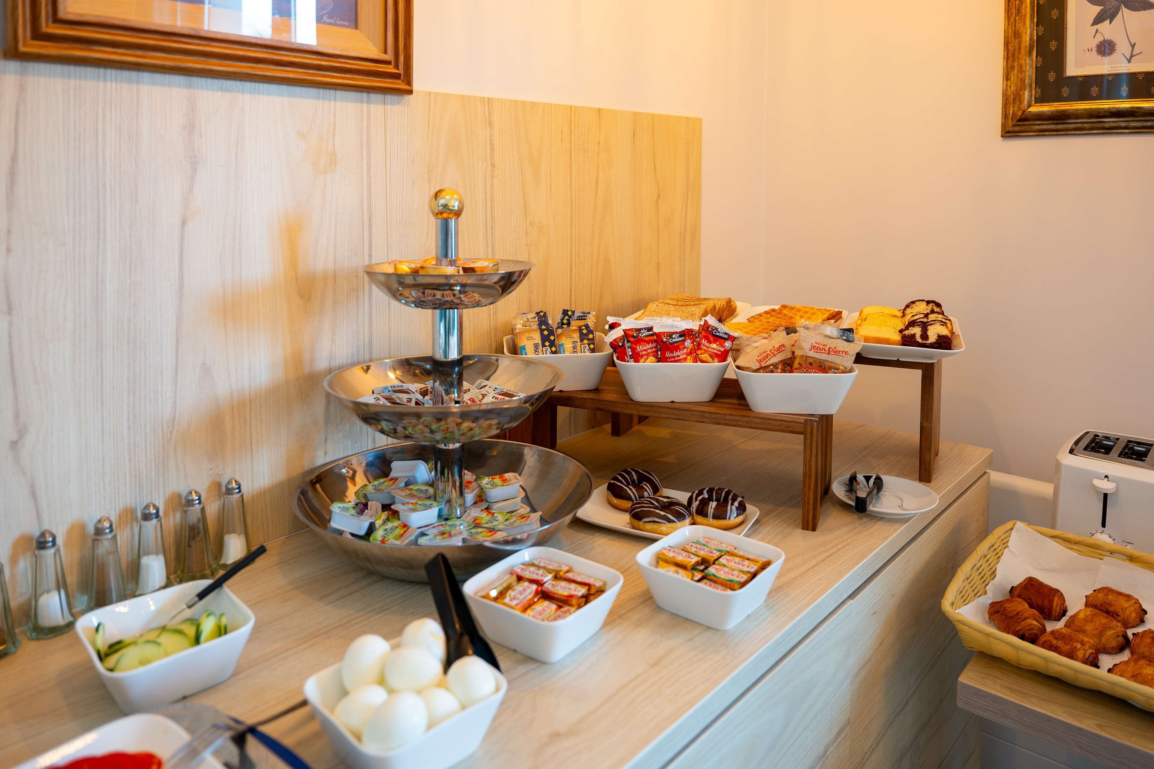 A buffet table with various food items and condiments.