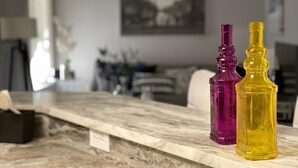 Una encimera de mármol con dos botellas de vidrio decorativas.