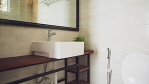 Une salle de bain moderne avec un lavabo blanc, un miroir et une douche.