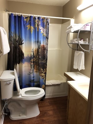 A bathroom with a toilet, shower, and sink. - Blue Moon Resort and Motel (Hill City)