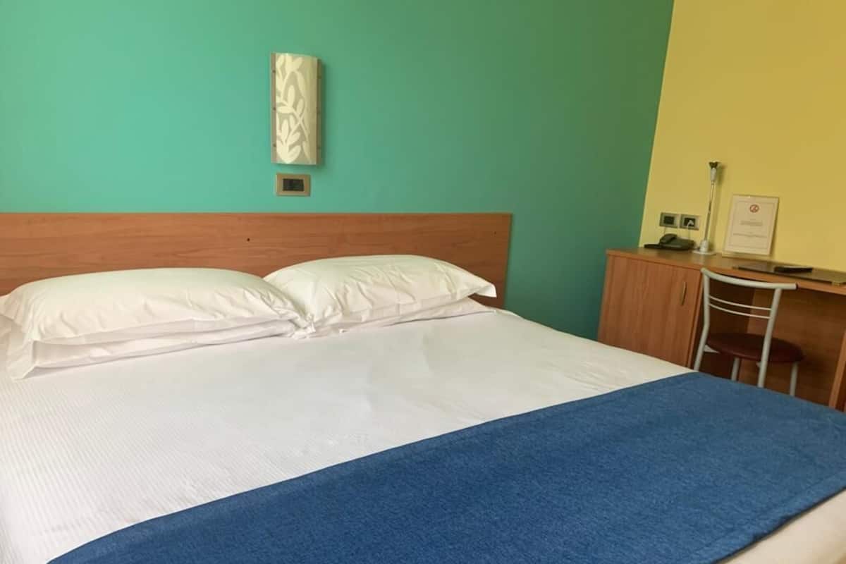 Copriletto in piuma, una scrivania, postazione laptop