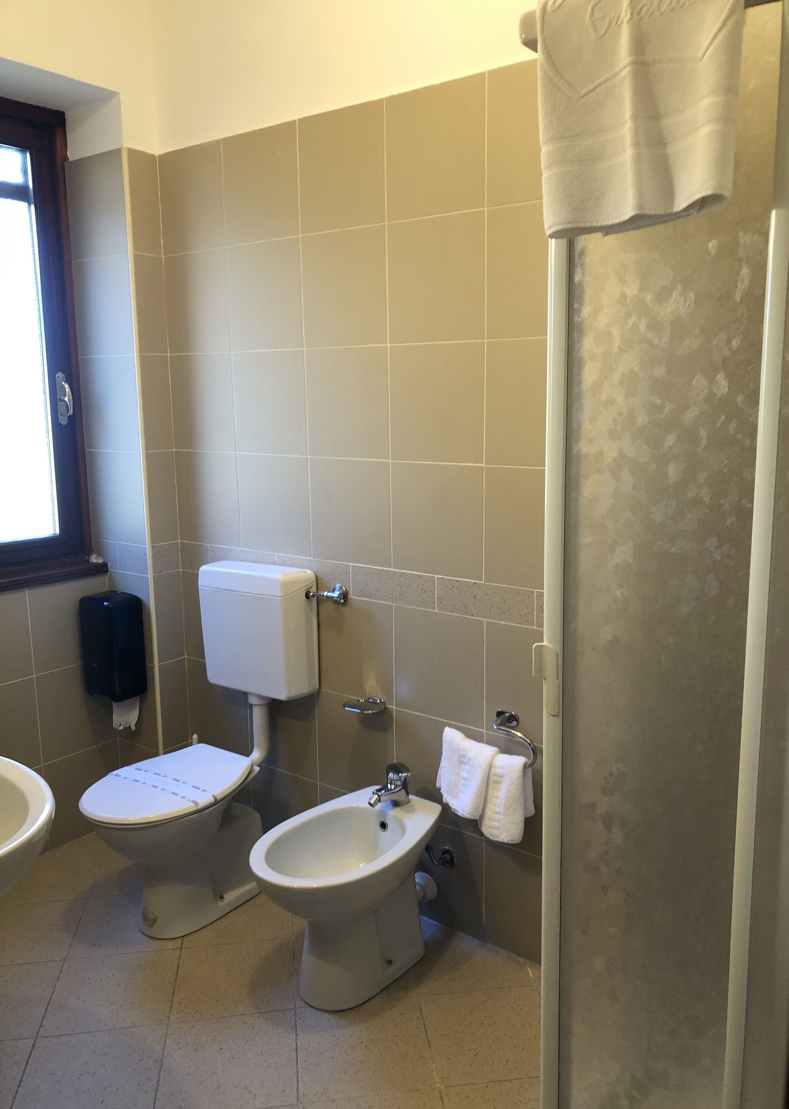 A bathroom with a toilet, bidet, and sink.